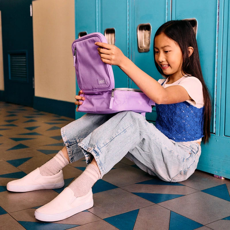 Child packing a purple PackIt lunch bag at school